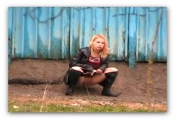 Девушка писает за автобусной остановкой