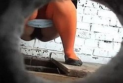 Писающих девушек снимают на камеру в уличном туалете