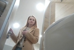 Блондинка выставив голую попу писает в туалете